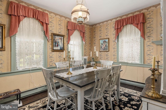 dining area featuring wallpapered walls, a baseboard heating unit, and plenty of natural light
