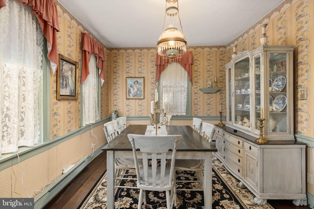dining area featuring wallpapered walls, a chandelier, and wood finished floors