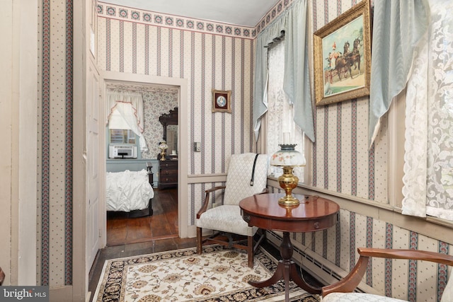 sitting room featuring cooling unit, wallpapered walls, and wood finished floors