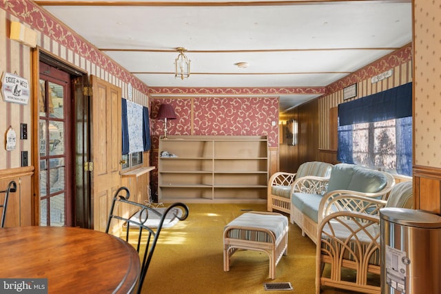 sitting room featuring wainscoting, carpet flooring, and wallpapered walls