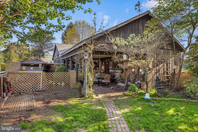 back of property with a yard and metal roof