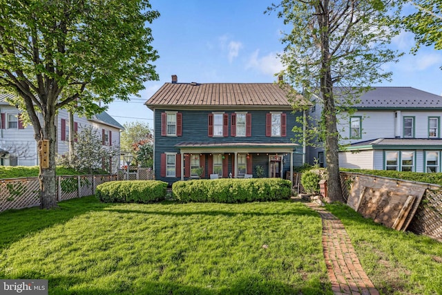 view of front facade with fence, covered porch, and a front yard