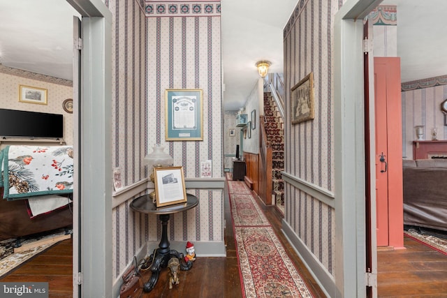 corridor with wood-type flooring and wallpapered walls