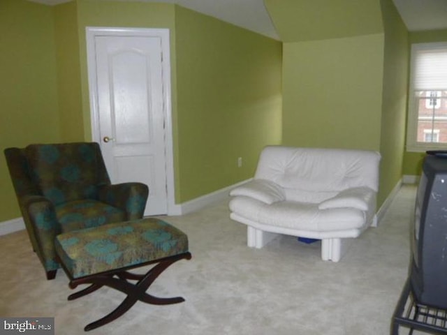 living area with baseboards, carpet flooring, and lofted ceiling