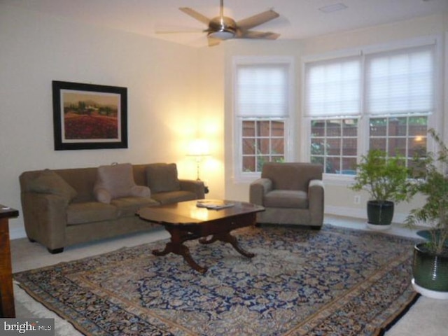 living area featuring a ceiling fan and a wealth of natural light