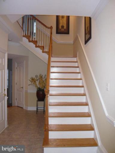 stairway with tile patterned flooring and baseboards