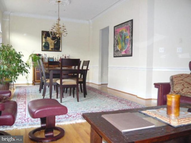dining room featuring crown molding, wood finished floors, and a chandelier