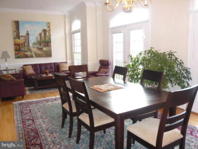 dining area featuring crown molding, wood finished floors, and a notable chandelier