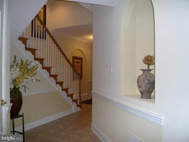 4906 Donovan Dr, Alexandria, VA 22304 - foyer entrance with arched walkways, stairway, tile patterned flooring, baseboards, and crown molding