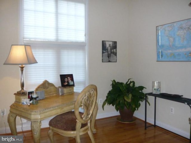 office area with baseboards and wood finished floors