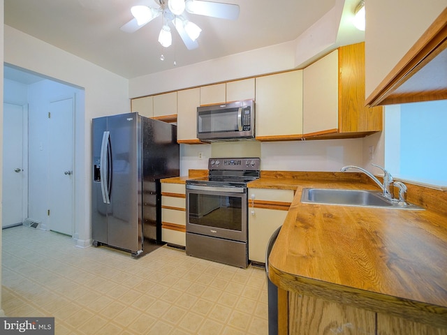 kitchen with light floors, ceiling fan, visible vents, a sink, and appliances with stainless steel finishes