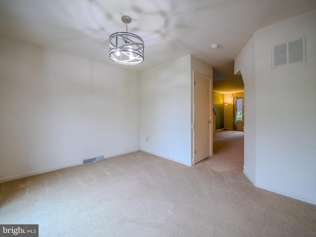 unfurnished dining area featuring light carpet, an inviting chandelier, and visible vents