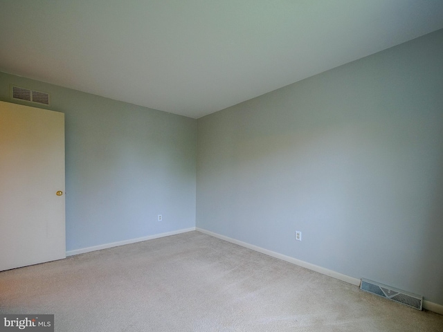 empty room with baseboards, visible vents, and carpet floors
