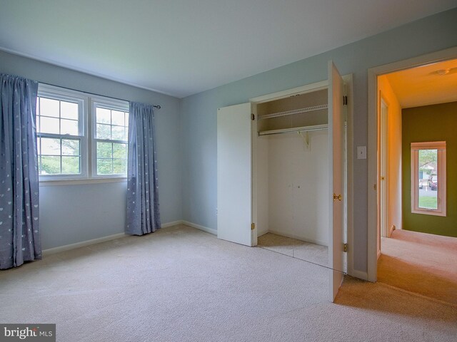 unfurnished bedroom featuring carpet, a closet, and baseboards