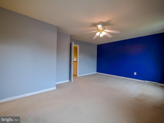 unfurnished room featuring carpet, baseboards, and a ceiling fan
