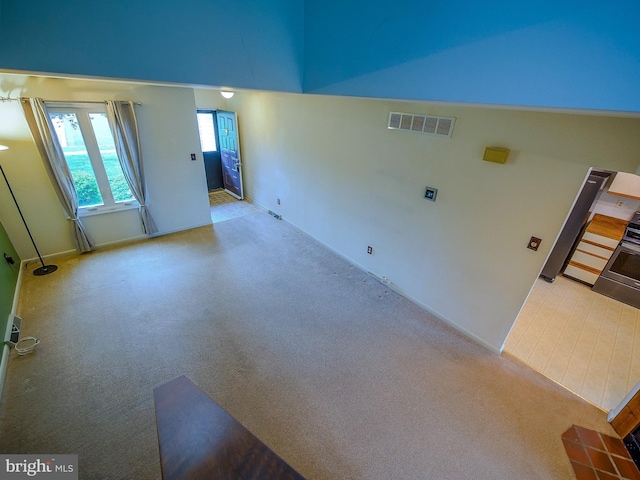 carpeted empty room featuring baseboards and visible vents