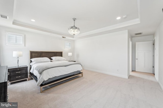 bedroom with crown molding, a tray ceiling, and visible vents