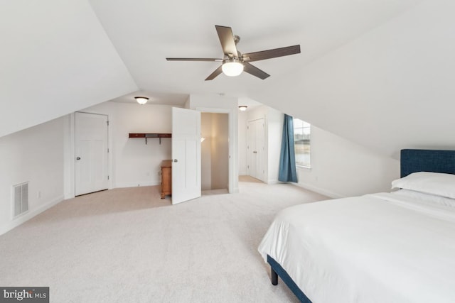 carpeted bedroom featuring ceiling fan, multiple closets, baseboards, lofted ceiling, and visible vents