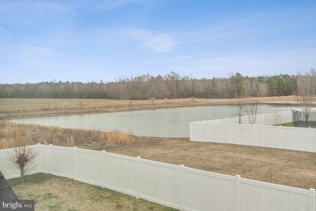 view of yard with fence and a tennis court