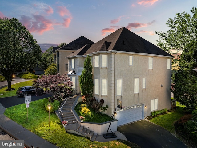 view of property exterior featuring driveway, a garage, stucco siding, and stairs