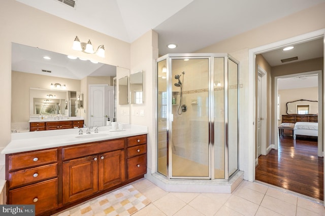 ensuite bathroom featuring tile patterned floors, a stall shower, and vanity