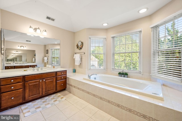 full bath with healthy amount of natural light, a bath, tile patterned flooring, and vanity