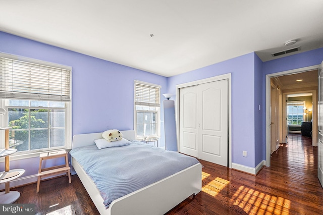 bedroom featuring a closet, wood finished floors, and baseboards