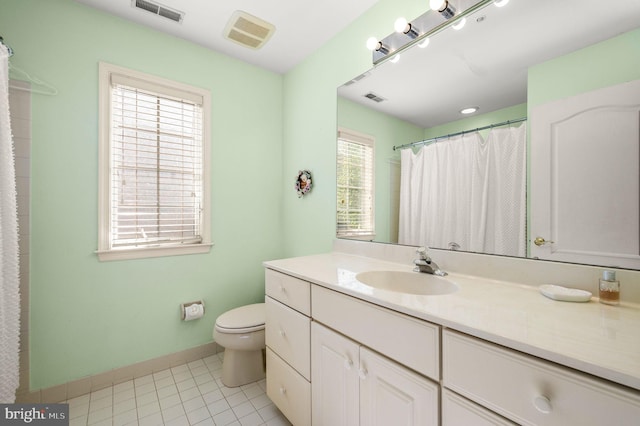 bathroom with toilet, vanity, baseboards, and tile patterned floors