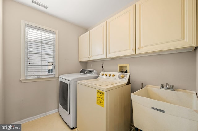 washroom featuring cabinet space, separate washer and dryer, and baseboards