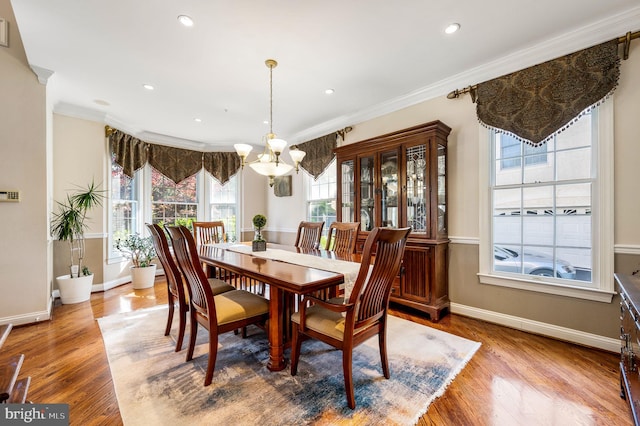 dining area with a chandelier, baseboards, ornamental molding, wood finished floors, and recessed lighting