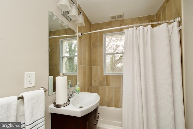 bathroom with vanity, tile walls, shower / bath combination with curtain, and visible vents