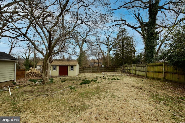 view of yard featuring an outdoor structure, a fenced backyard, and a storage unit