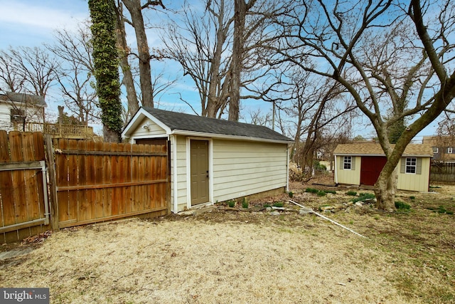 garage with a storage shed and fence