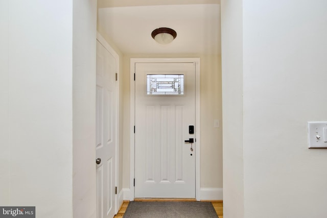 entryway with baseboards and light wood finished floors