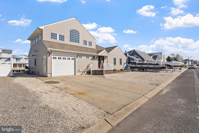 traditional-style home featuring a residential view, an attached garage, and driveway