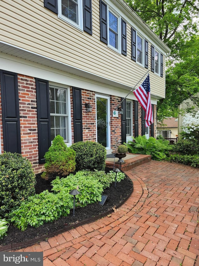 entrance to property featuring brick siding