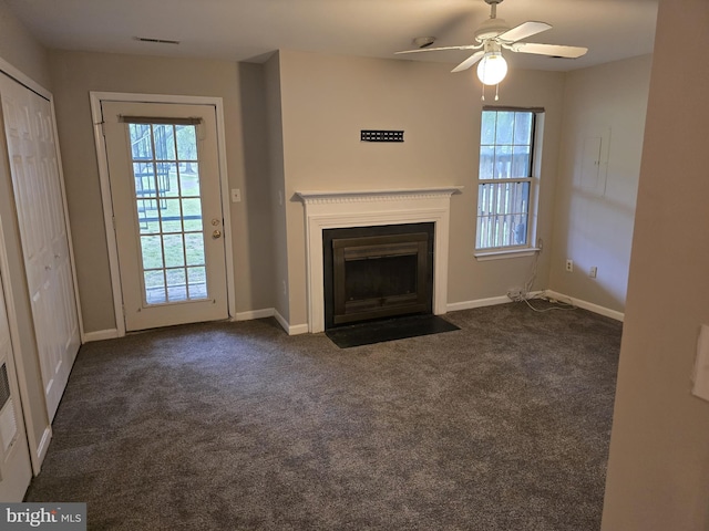unfurnished living room with a fireplace with flush hearth, ceiling fan, plenty of natural light, and baseboards