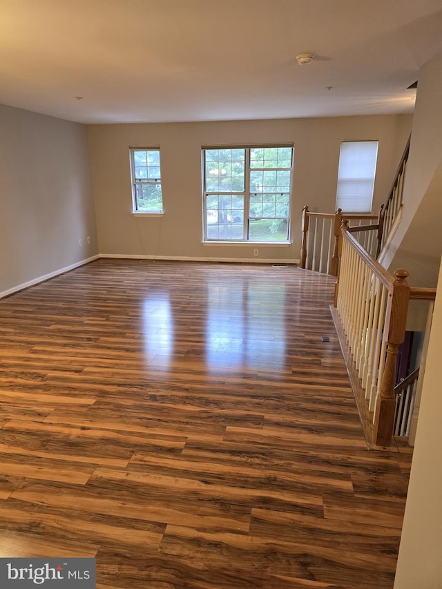 unfurnished room with dark wood finished floors, baseboards, and a smoke detector