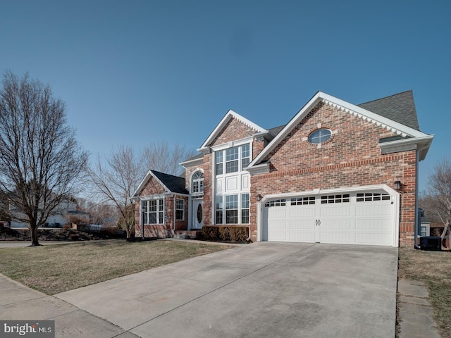 traditional home with driveway, a front yard, brick siding, a garage, and roof with shingles