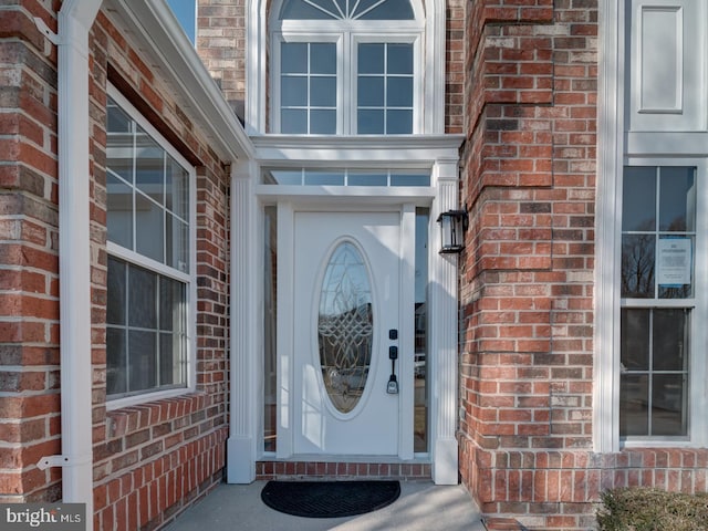 doorway to property featuring brick siding