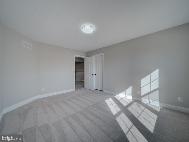 carpeted empty room with baseboards