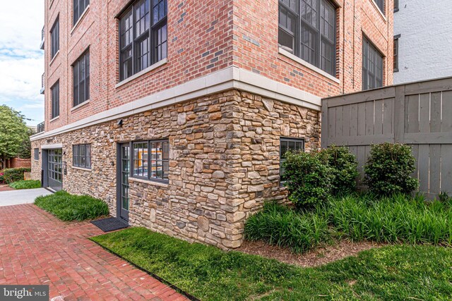 521 N Washington St Unit 201, Alexandria, VA 22314 - view of property exterior with brick siding, an attached garage, fence, and stone siding