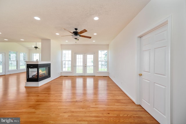 9129 Pebble Beach Ln, King George, VA 22485 - unfurnished living room with recessed lighting, light wood-style flooring, a textured ceiling, ceiling fan, and a multi sided fireplace