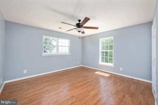 9129 Pebble Beach Ln, King George, VA 22485 - empty room with plenty of natural light, a ceiling fan, wood finished floors, baseboards, and a textured ceiling