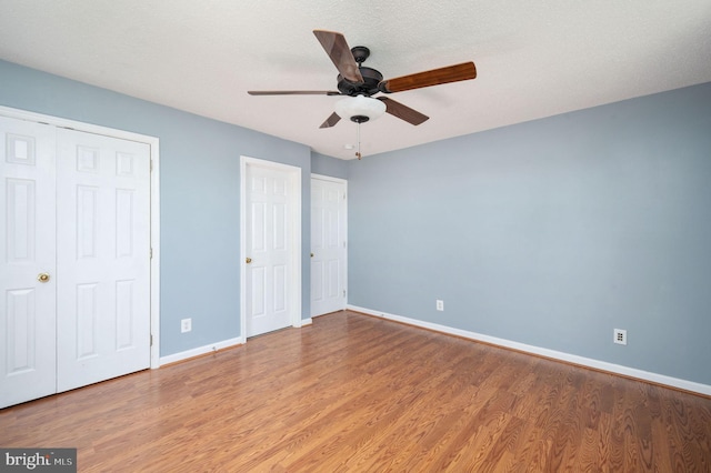 9129 Pebble Beach Ln, King George, VA 22485 - unfurnished bedroom with baseboards, wood finished floors, and a ceiling fan