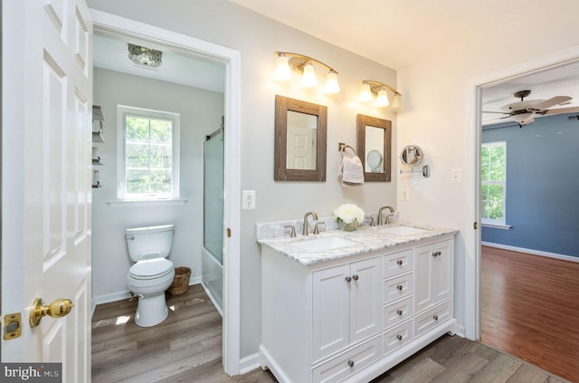 9129 Pebble Beach Ln, King George, VA 22485 - bathroom with wood finished floors, toilet, double vanity, and baseboards