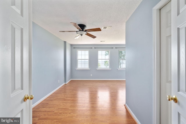 9129 Pebble Beach Ln, King George, VA 22485 - unfurnished room featuring a textured ceiling, light wood-type flooring, ceiling fan, and baseboards