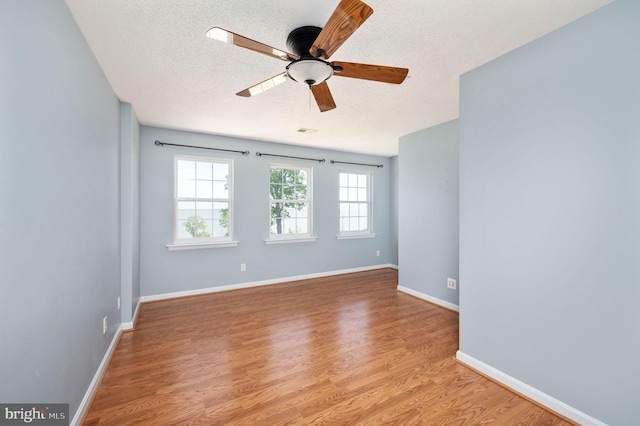 9129 Pebble Beach Ln, King George, VA 22485 - spare room featuring a textured ceiling, light wood-type flooring, ceiling fan, and baseboards