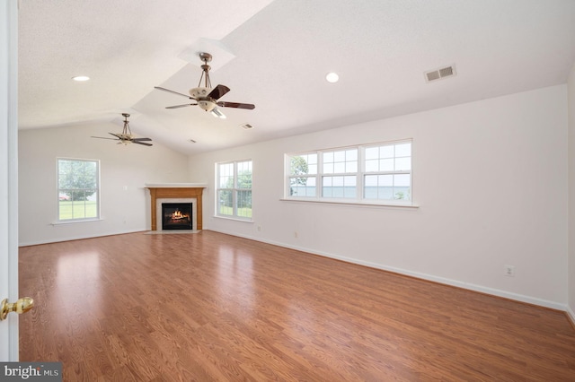 9129 Pebble Beach Ln, King George, VA 22485 - unfurnished living room with plenty of natural light, wood finished floors, lofted ceiling, ceiling fan, and a fireplace with flush hearth
