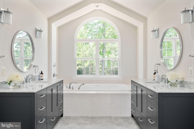 9129 Pebble Beach Ln, King George, VA 22485 - bathroom featuring lofted ceiling, a garden tub, tile patterned floors, two vanities, and a textured ceiling